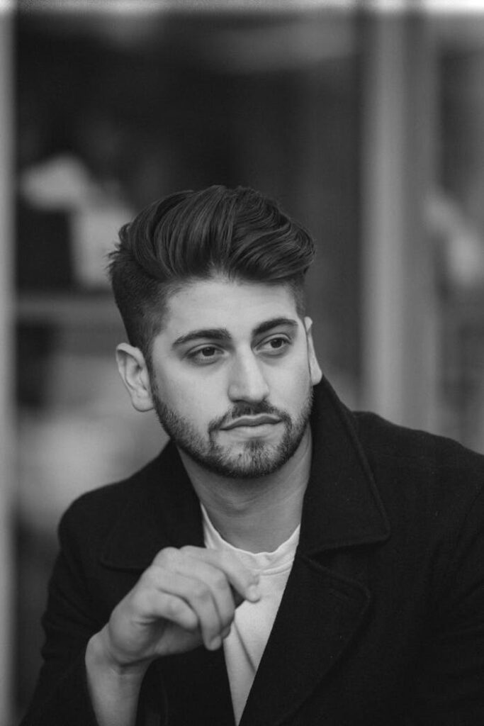 pexels-photo-4969919 Black and white portrait of a stylish, thoughtful man with beard, looking away contemplatively.